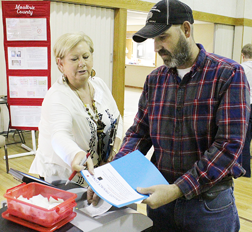 Photo by Mike Brothers Election Day Sullivan Precinct #6 voters were in the polling place at First United Methodist Church Nov. 8. Above Kurt Thompson prepares to place his ballot in the voting tabulator with some instruction from election judge Angie Coy.