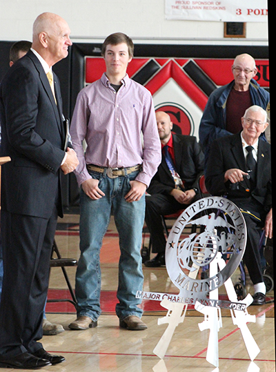 Photo by Mike Brothers Veterans Honored on November 11 included keynote speaker retired Marine Major Lynn Lowder. Lowder was presented a personalized Marine Corp emblem from students as a token of their appreciation for his service. Pictured to the right of Major Lowder is Career English senior Trey Garriott while veterans look on during the Sullivan High School ceremony. 