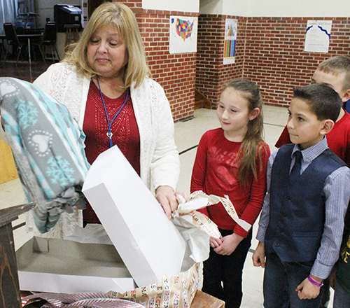 Photo by Mike Brothers Okaw Valley Honors Teacher During an awards ceremony at Okaw Valley Elementary School a special honor was given retiring teacher Debbie Weinstock. Members of Weinstock’s third grade class presented her with a quilt they made for her in class without her knowledge. Principal Doug McCausland pointed out the students had Mrs. Weistock pick material for the quilt they secretly made for her.